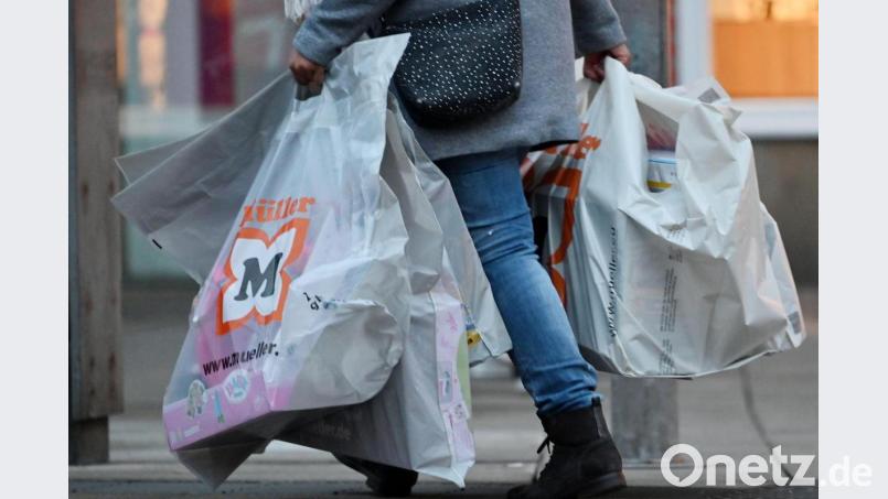 Eine Frau trägt Einkaufstüten durch das Stadtzentrum. Bild: Martin Schutt/dpa