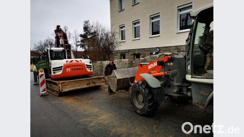 Pfarrer Erwin Bauer macht sich ein Bild über die ersten Baumaßnahmen an der Steinmauer. Die Baufirma Spichtinger aus Schönsee rückt noch zwei Wochen vor Weihnachten mit Bagger und Raupe an. Bild: gz