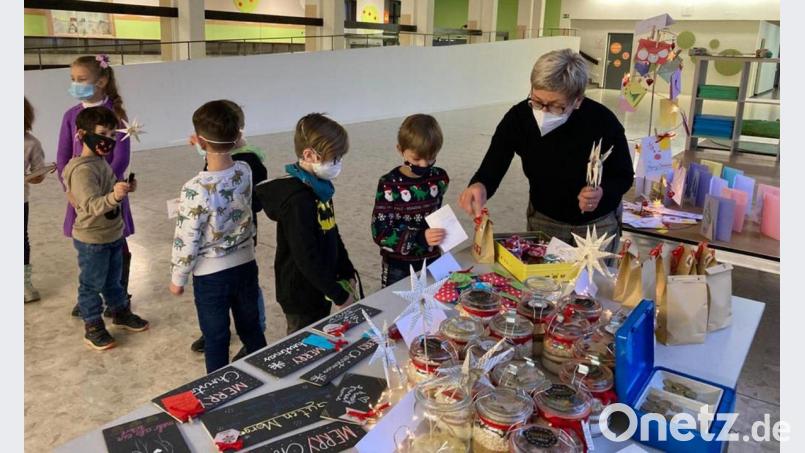 Lehrerin Petra Raithel mit ihren kleinen Kunden beim Weihnachtsbasar in der Aula der Jobst-vom-Brandt-Schule. Bild: Jobst-vom-Brandt-Schule/exb