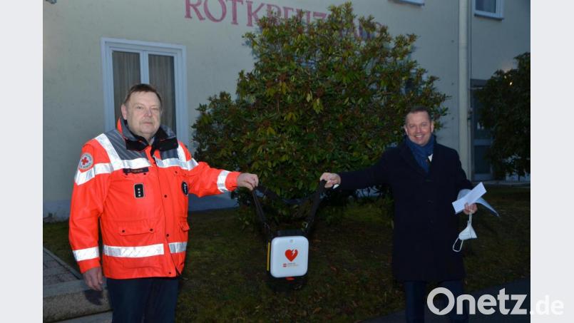 Vorstandschef Gerhard Hösl von der Vereinigten Sparkasse (rechts) übergab den kleinen Lebensretter mit dem roten Herz an stellvertretenden Bereitschaftsleiter Josef Solfrank (links). Der Defibrillator soll ab sofort zum ständigen Begleiter der Rotkreuzler bei Absicherungen und vielem anderen mehr werden. Bild: dob