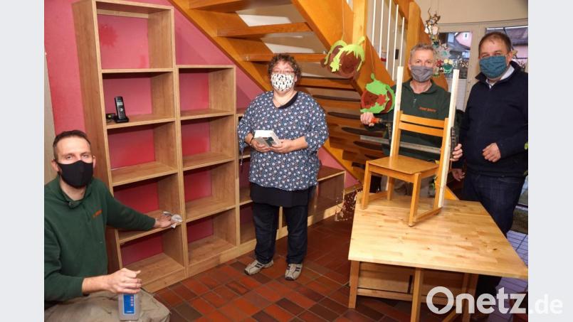 Unter der Treppe ist ausreichend Platz für ein Regal für viele Bücher. Gespendet hat es Josef Birkner (Zweiter von rechts), der es mit Hannes Heining auch eingebaut hat. Silke Höllerer und Kinderdorfleiter Holger Hassel sind froh, dass Birkner auch einen aus dem Leim gegangenen Kinderstuhl gleich wieder zusammengefügt hat. Bild: bkr