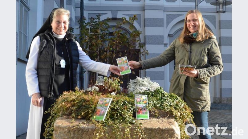 Äbtissin Laetitia Fech und Johanna Härtl, Leiterin der Geschäftsstelle der Stiftung Kultur- und Begegnungszentrum Abtei Waldsassen, präsentieren im Pfortenhof des Klosters die Infobroschüre. Bild: Johanna Härtl/exb