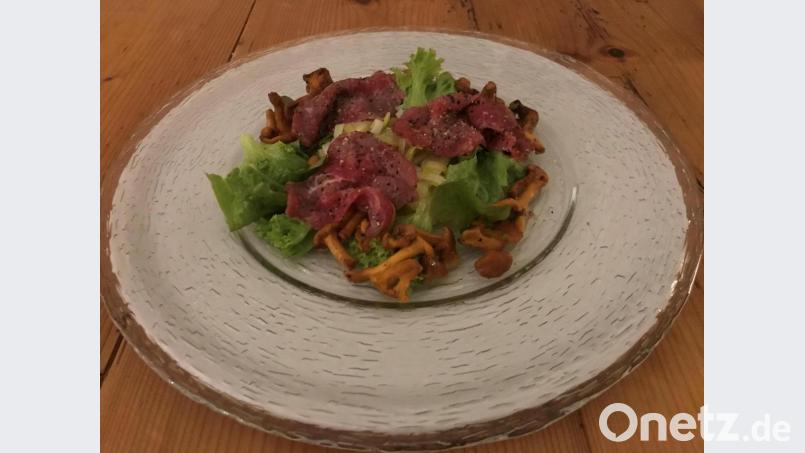 Durch die Marinade gezogen wird das hauchdünn geklopfte Rinderfilet. Den gekochten Lauch verfeinert eine Marinade aus verschiedenen Essigen. Angerichtet wird mit Blattsalat und gedämpften Pfifferlingen. Bild: Michael Schiffer