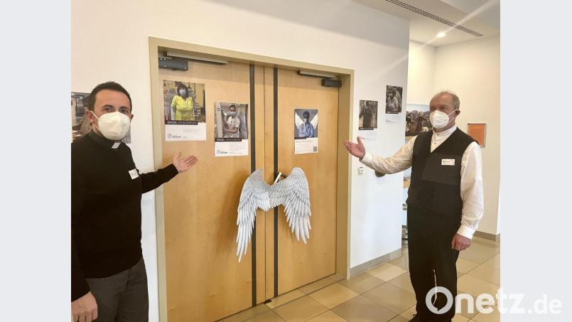 Die beiden Pfarrer Stefan Fischer (links) und Heinrich Arweck zeigen die Aktion &quot;Engel im Krankenhaus&quot; an Eingangstür zur Kapelle. Bild: wku