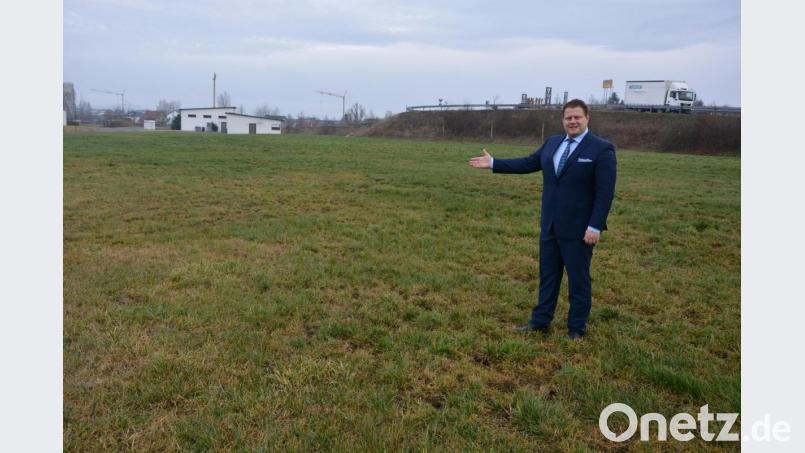 Bürgermeister Stefan Grillmeier deutet auf die Fläche im Gewerbegebiet &quot;Kreuzäcker&quot;, wo ein Unternehmen nahe der BRK-Rettungswache (im Hintergrund) ein Neubauprojekt realisieren will. Bild: jr