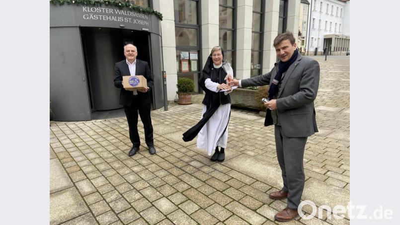 Bei der Übergabe des Geschenkpackersl sowie des Glaskreuzes aus der Glashütte Lamberts auf dem Pfortenhof des Klosters, von links Armin Wolf, Äbtissin Laetitia Fech und KJF-Direktor Michael Eibl. Bild: Sr. M. Sophia Schlembach/exb
