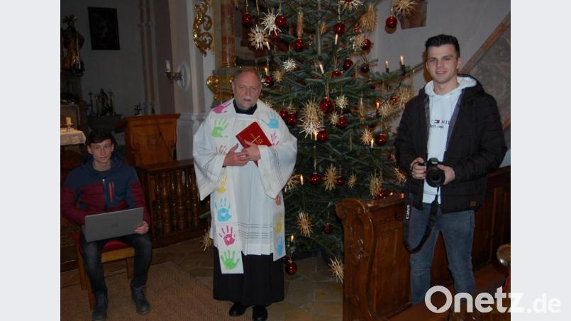 Da wegen der Corona-Pandemie viele Gläubige keinen Weihnachtsgottesdienst besuchen können, kommt Pfarrer Alfons Forster zur Einstimmung auf das Weihnachtsfest per Video in die Haushalte. Die KLJB‘ler Elija Hammer (rechts) und Jakob Hammer (links) lieferten dazu die Idee und setzten sie technisch um. Bild: grm