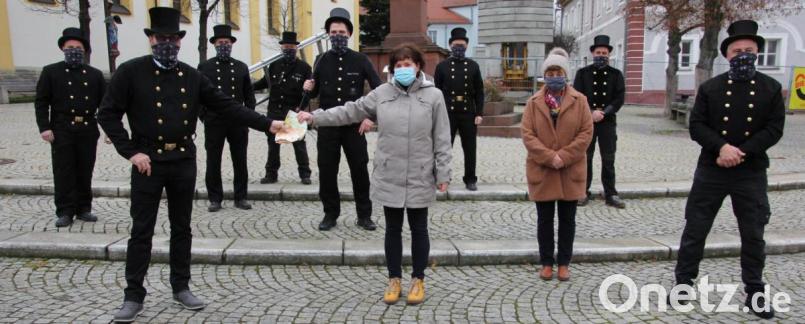 Imposantes Bild vor der Mitterteicher Stadtpfarrkirche: Manuel Schätzler (vorne, links), Schulungsstellenleiter der Kaminkehrerinnung Oberpfalz, überreichte im Beisein weiterer sieben Kaminkehrermeister 4000 Euro an Elke Bauer und Gunda Bauer von der Wohngemeinschaft St. Benedikt. Bild: kro