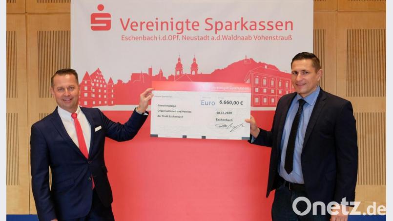 Eschenbachs Bürgermeister Marcus Gradl (rechts) nimmt den symbolischen Spendenscheck über 6660 Euro aus den Händen von Vorstandsvorsitzendem Gerhard Hösl (links) entgegen. Die Vereine und Institutionen freuen sich über die finanzielle Zuwendung der Vereinigten Sparkassen Eschenbach, Neustadt/WN, Vohenstrauß so kurz vor dem Weihnachtsfest. Bild: dob