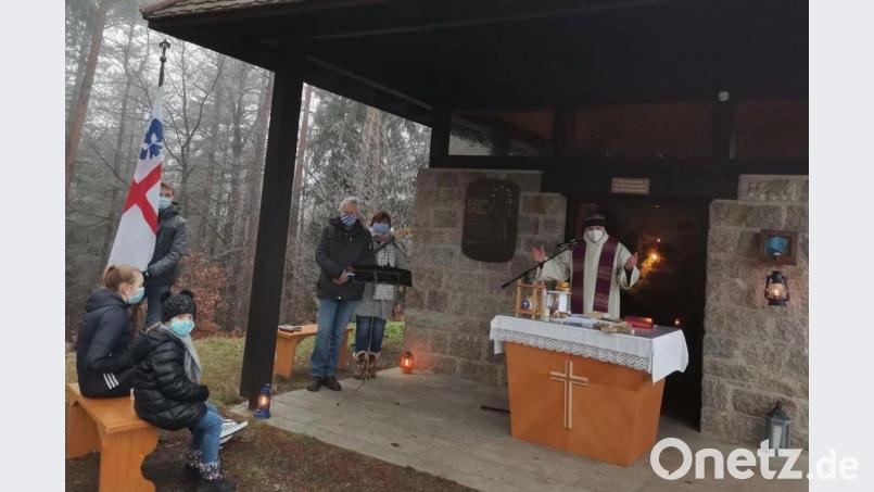 Das Friedenslicht wird bei der Messe an der Nepomukkapelle am Buchberg, die Pfarrer Josef Irlbacher zelebriert, an die Messbesucher weitergegeben. Bild: ads