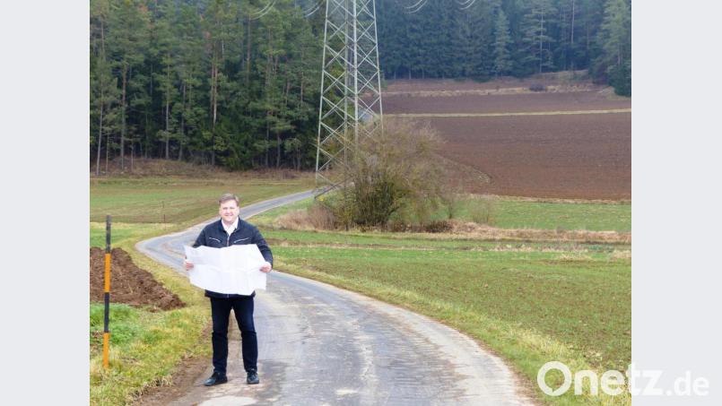 Bürgermeister Stefan Braun erläutert bei einem Ortstermin an Hand eines Plans den geplanten Ausbau der Gemeindeverbindungsstraße zwischen Dettnach und Drahberg, der im kommenden Jahr über die Bühne gehen soll. Bild: jp