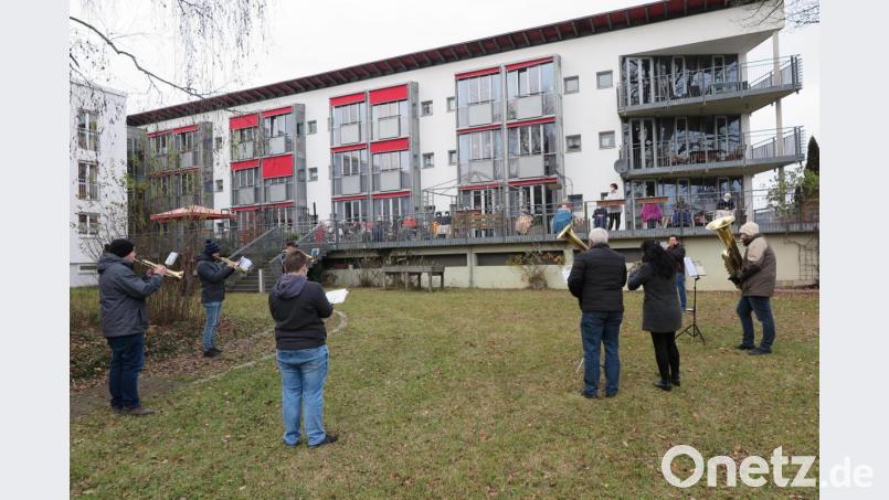 Auf der Terrasse des Seniorenzentrums Haus Falkenstein freuten sich die Heimbewohner und Heimleiterin Claudia Heier (auf der Terrasse stehend) über die musikalischen Weihnachtsgrüße der Stadtkapelle Kemnath. Bild: jzk