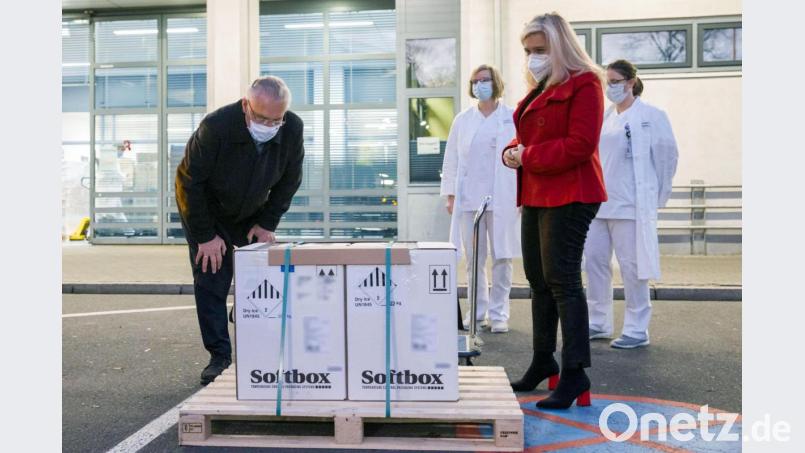 Joachim Herrmann (CSU), Innenminister von Bayern, und Melanie Huml (Zweite von rechts, CSU), Gesundheitsministerin von Bayern, stehen neben Kartons mit den ersten Dosen Corona-Impfstoff für Bayern. Bild: Daniel Karmann/dpa