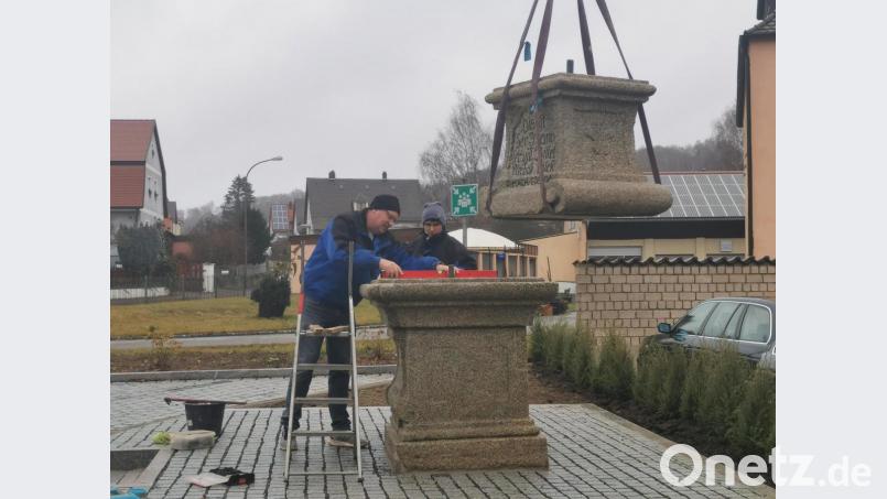 Am Kranhaken hängt der obere Teil des Sockels, der untere steht schon fest. Bald kann die Sandsteinfigur des Heiligen Johannes von Nepomuk heimkehren. Bild: cog