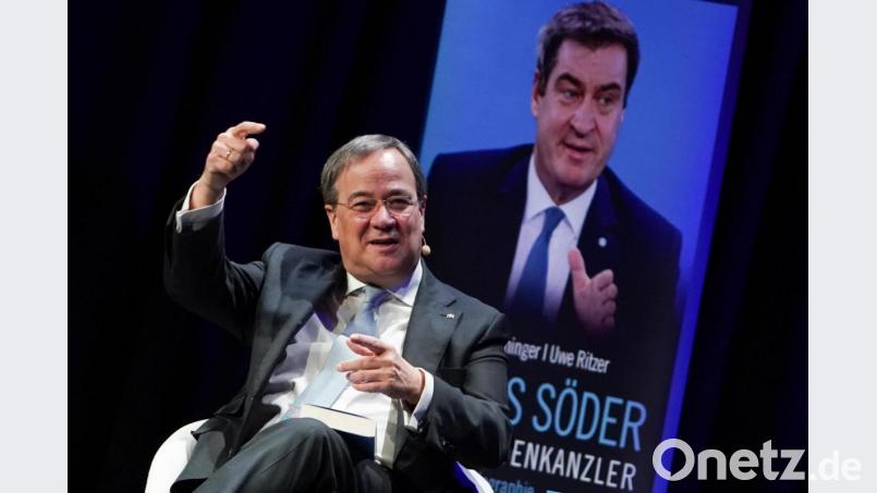 Noch hält sich die Angst der CDU vor einem CSU-Schattenkanzler in Grenzen: Armin Laschet (CDU), einer der Kandidaten für den CDU-Vorsitz, präsentiert augenzwinkernd die Biographie "Markus Söder - Der Schattenkanzler". Bild: Jörg Carstensen/dpa