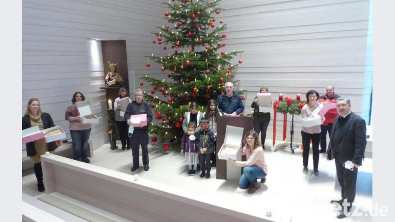 Mit Geschenken um den Christbaum der Hauskapelle sind versammelt stellvertretende Hausleiterin Jasmin Kovacs (links), Engelbert Mayer von der Tafel Weiden-Neustadt (Vierter von links), Reinhold Birner vom Netzwerk Asyl Weiden (Mitte) mit vier Kindern aus Flüchtlingsfamilien, Direktor Manfred Strigl (rechts) und das Küchenpersonal.
