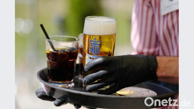 Ein Kellner arbeitet in einem Biergarten und trägt dabei Gummihandschuhe. Mit den Einschränkungen in der Corona-Krise ist die Zahl geringfügig Beschäftigter deutlich zurückgegangen. Minijobs sind oft die ersten, die in der Krise wegbrechen. Bild: Sebastian Willnow/dpa