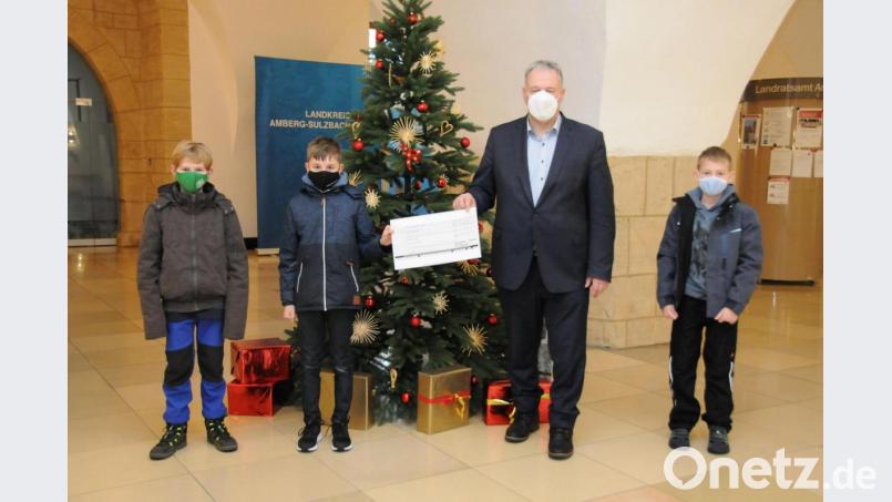 Landrat Richard Reisinger bedanke sich bei dem neunjährigen Jonas (von links), Benjamin (10) und Konstantin (9) für ihre großzügige Spende für sozial schwächere Menschen im Landkreis Amberg-Sulzbach. Bild:  Christine Hollederer/exb