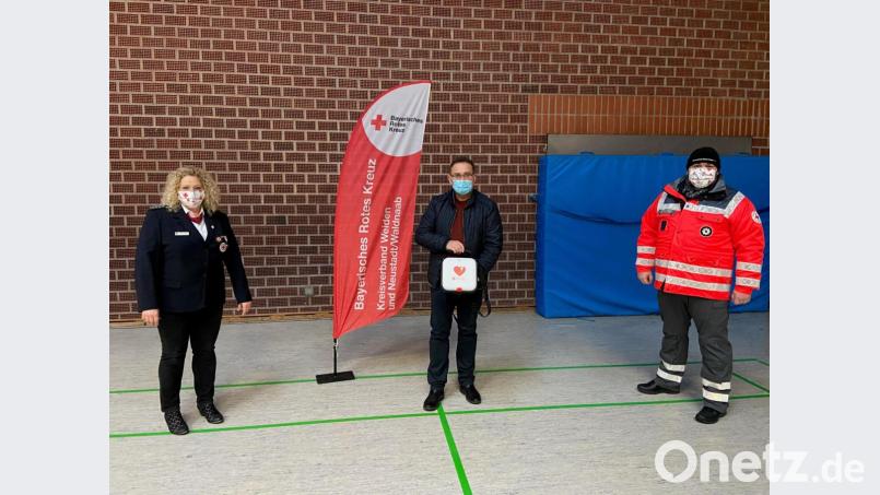 Bereitschaftsleiterin Sieglinde Steiner (von links) nimmt den „Defi“ mit dem roten Herz von Spender Josef Bock im Beisein von Ausbilder Jürgen Göppl entgegen. Bild: BRK/Bock/exb