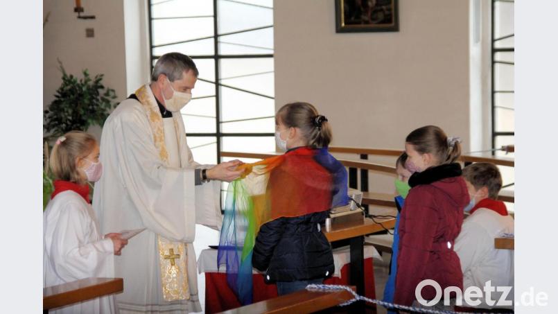 Pfarrer Werner Sulzer legte den Kindern und Jugendlichen zur Segnung ein Tuch über die Schulter. Bild: bjo