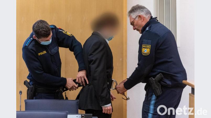 Dem Angeklagten werden im Verhandlungssaal des Landgerichts von Polizisten die Handschellen abgenommen. Die Staatsanwaltschaft wirft dem Mann vor, Maria Baumer im Mai 2012 in der gemeinsamen Wohnung in Regensburg mit Medikamenten getötet zu haben. Bild: Armin Weigel