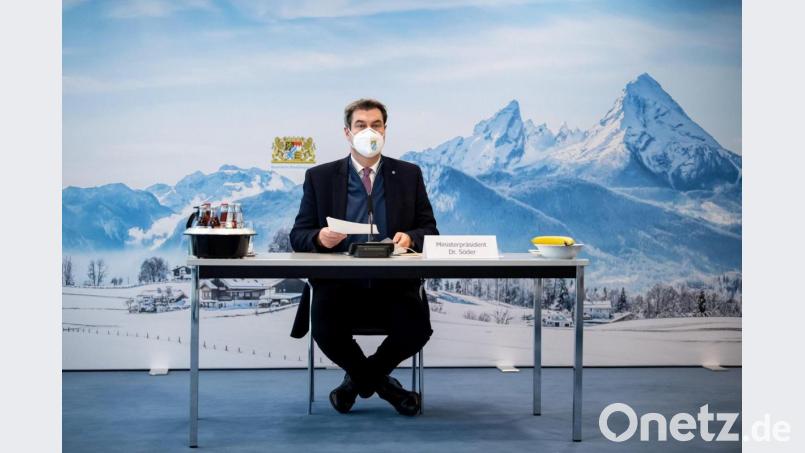 Markus Söder (CSU), Parteivorsitzender und Ministerpräsident von Bayern, sortiert zu Beginn einer Sitzung des Ministerrats in der Staatskanzlei seine Unterlagen. Hinter ihm ist ein großformatiges Foto zu sehen, das die winterliche Landschaft um den Watzmann im Berchtesgadener Land zeigt. Bild: Matthias Balk/dpa