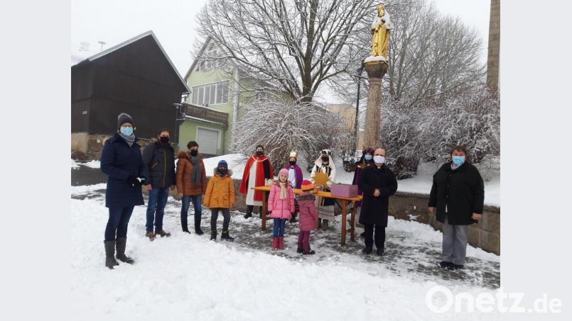 Eine Gruppe der Dreikönige mit Pfarrer Armin Maierhofer und Gottesdienstbesuchern bei der Sammelaktion. Bild: Rosa Schöner/exb