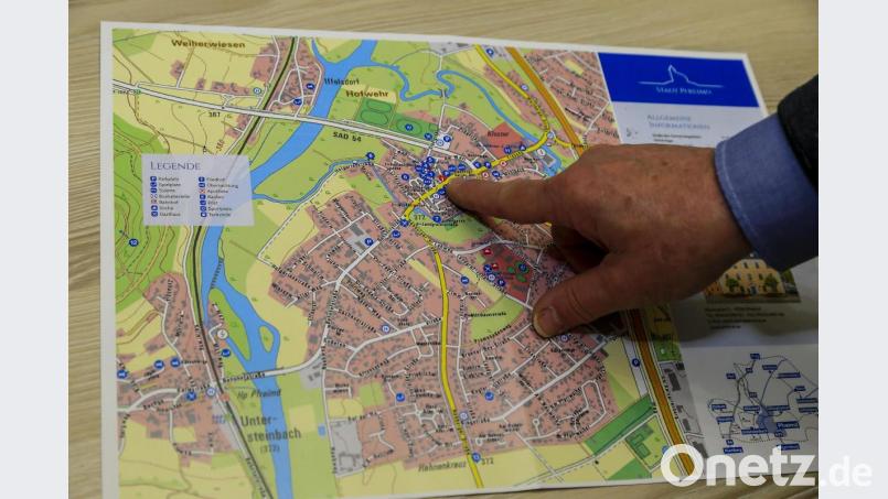 Der neue Stadtplan für Pfreimd kommt als Abreißblock. Für Gäste sind die Sehenswürdigkeiten und wichtigsten Anlaufstellen eingezeichnet. Bürgermeister Richard Tischler deutet auf das Rathaus am Marktplatz. Bild: Hösamer