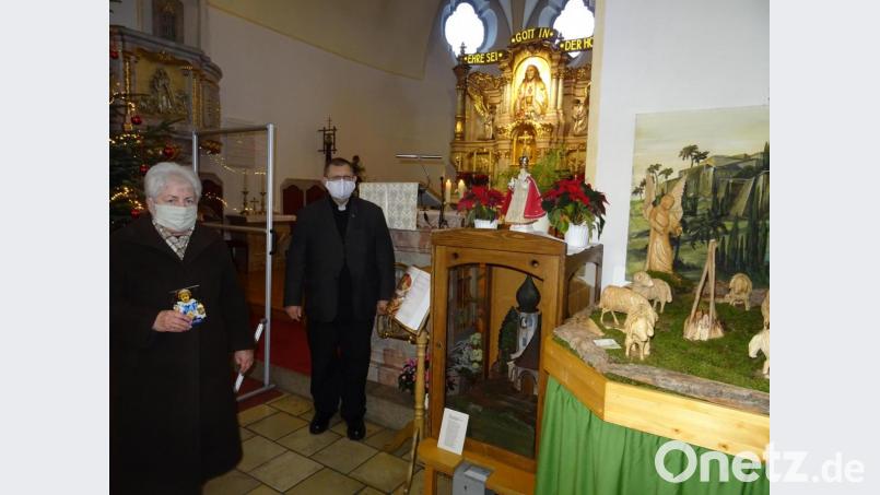 Margarete Schulda und Pfarrer Robert Ploß bei der Nachbildung des &quot;Prager Jesuleins&quot; in der Pfarrkirche Herz Jesu in Pechbrunn. Bild: apr