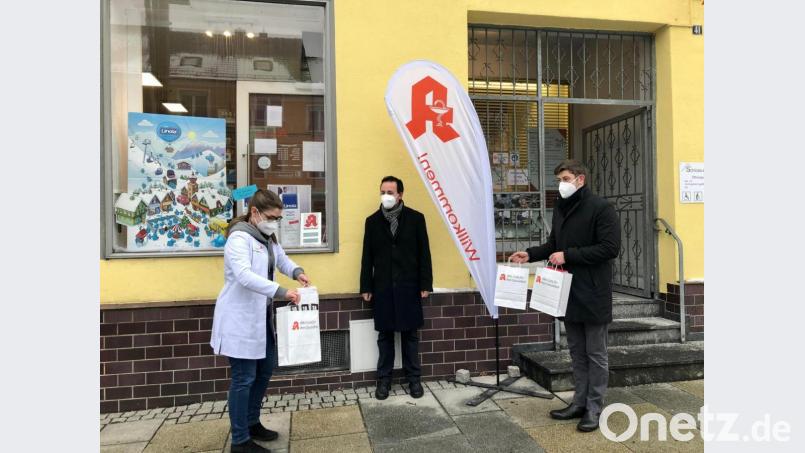 Carina Eichenseer (links) und Andreas Schießler (rechts) übergeben Pfarrer Stefan Fischer (Mitte) die Maskenspenden. Bild: wku