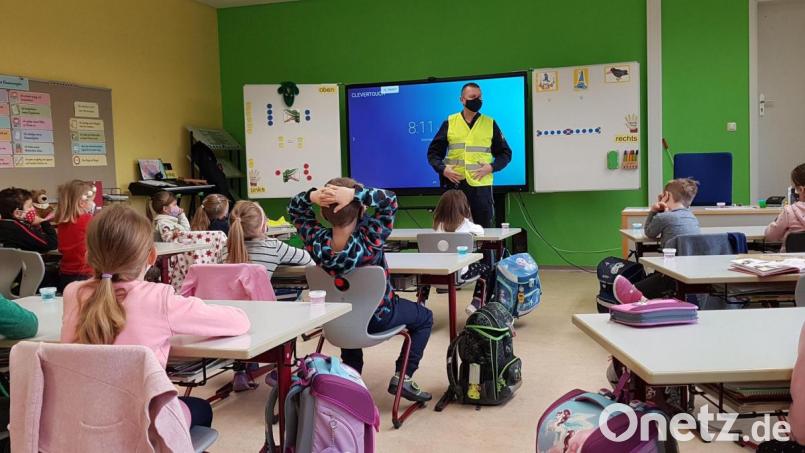 Busschule unter Corona-Bedingungen: Polizeioberkommissar Markus Neumeyer erklärte im Klassenzimmer den Kindern, wie wichtig reflektierende Westen für die Sicherheit auf dem Schulweg sind. Bild: Polizeiinspektion Amberg/exb