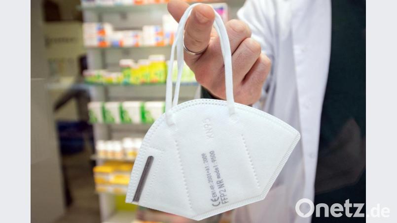 Ein Apotheker hält eine FFP2-Maske an einem Finger. Foto: Friso Gentsch/dpa Bild: Friso Gentsch