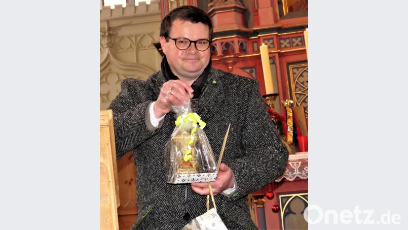 Kirchengemeindevorstand Thomas Bäumler hatte zum Abschied eine große Kerze als Geschenk mitgebracht. Bild: ubb