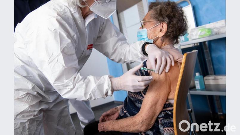 Eine Mitarbeiterin des Bayerischen Roten Kreuzes (BRK) impft die 100-jährige Juliana Pauler in einem Impfzentrum mit dem Impfstoff gegen das Corona-Virus SARS-CoV-2 von Biontech/Pfizer. Bild: Sven Hoppe/dpa