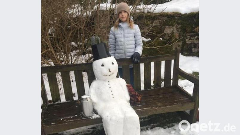 Anna zusammen mit dem Schneemann, der auf der Bank beim Schlosses Hardeck Platz genommen hat. Bild: Martina Söllner-Gradl/exb
