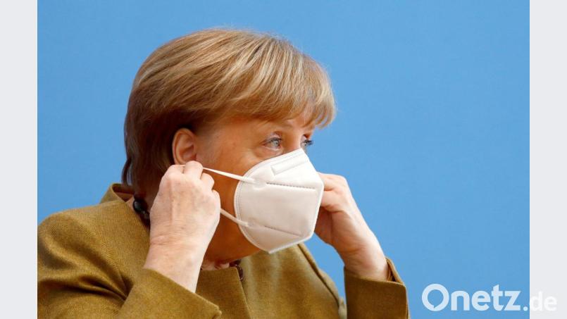 Bundeskanzlerin Angela Merkel (CDU) setzt nach einer Pressekonferenz im Haus der Bundespressekonferenz ihre Gesichtsmaske wieder auf. Thema waren unter anderem die Beschlüsse von Bund und Ländern zur Bekämpfung der Corona-Pandemie. Bild: Fabrizio Bensch/Reuters/Pool/dpa
