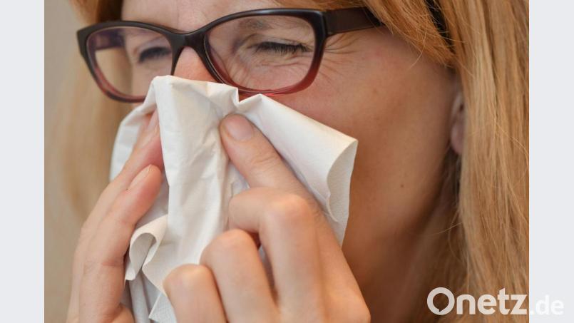 Eine Frau schnäuzt sich die Nase mit einem Papiertaschentuch. Symbolbild: Patrick Pleul/dpa
