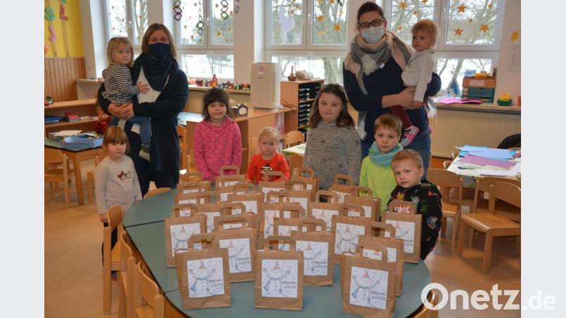 Kinderhausleiterin Sabine Doß (links), Erzieherin Steffi Spörrer und die Kinder der Notgruppe stellten die 50 &quot;Fröhlichen Wintertaschen&quot; vor, die in den kommenden Tagen abgeholt werden können. Bild: jr