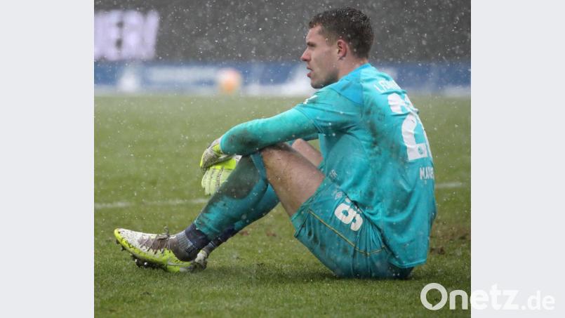 Torwart Christian Mathenia sitzt enttäuscht im Nürnberger Schneetreiben. Der Club ging am Sonntag gegen Hannover 96 mit 2:5 unter. Bild: Daniel Karmann/dpa