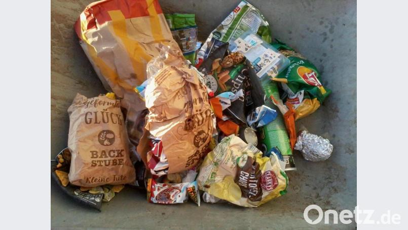 Tüten für Knabbereien und Backwaren haben Unbekannte in die Mülltonne des Friedhofes geworfen. Bild: bkr