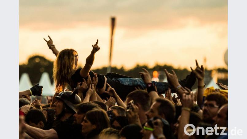 Während eines Konzerts wird ein Fan beim Crowd-Surfing auf Händen getragen. Symbolbild: Christophe Gateau/dpa