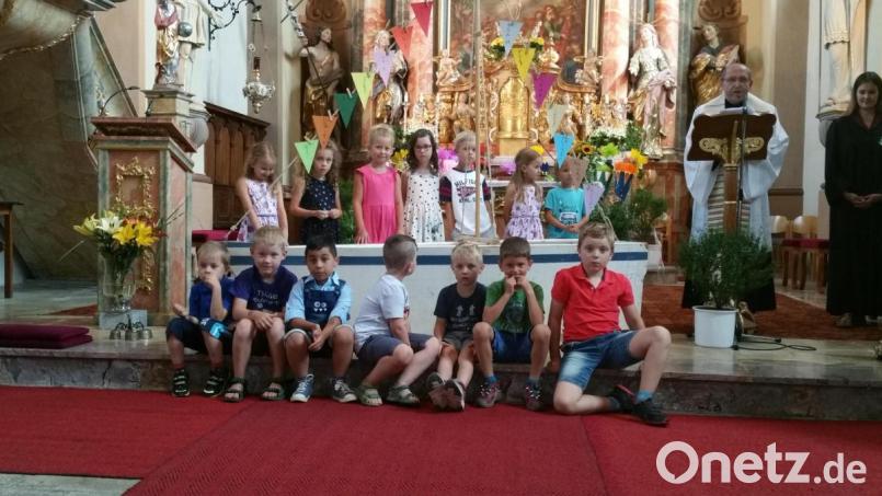 Das Kindergarten-Jahr der Kindertagesstätte Regenbogen in Beidl geht mit einer Abschlussandacht zu Ende. Sophia Scherm und Pfarrer Thomas Thiermann (von rechts) verabschieden 15 Vorschulkinder mit der „Aktion Schiff“. Bild: gbj