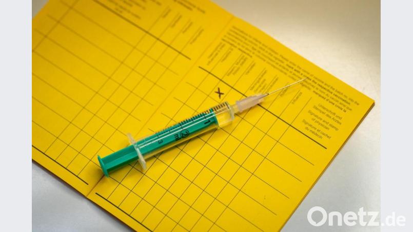 Eine Spritze liegt auf einem Impfpass. Symbolbild: Friso Gentsch