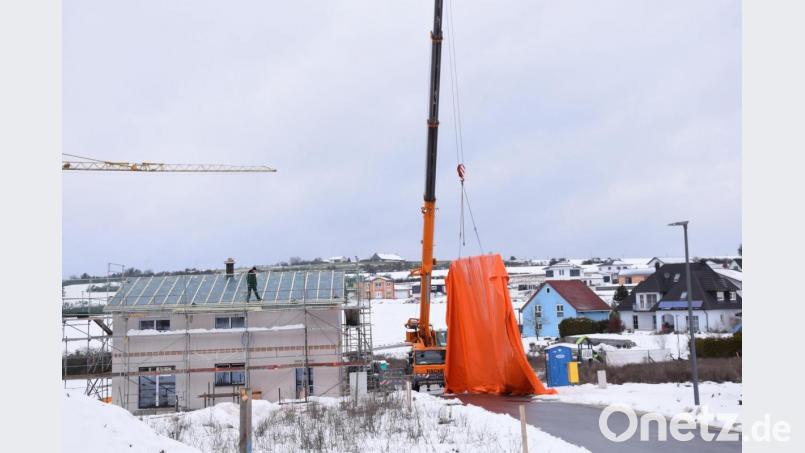 Das Wohnbaugebiet Ledererhang in Schmidmühlen ist trotz des Winters eine Großbaustelle. Autokräne sind derzeit dabei, Fertighäuser aufzustellen. Manchmal schaut es aus wie bei Christo, als er vor 25 Jahren in Berlin den Reichstag verhüllt hat. Doch hier geht es nicht um Kunst, die riesigen Planen schützen die Bauten vor Schnee und Regen. Bild: bö