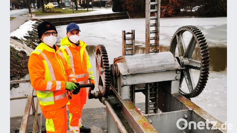 Bauhofleiter Peter Wolf (rechts) und Bauhofarbeiter Josef Schultes (links) kontrollieren das Wehr am Kemnather Stadtweiher und regulieren mit der Kurbel das Wehr und damit den Wasserstand im Stadtweiher. Bild: mde