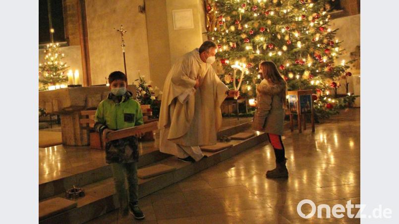 Am Ende des feierlichen Gottesdienstes im weihnachtlichen Licht der Christbäume spendete Pfarrer Hannes Lorenz den Blasius-Segen und überreichte den Kindern die gesegneten Kommunionkerzen. Bild: bph