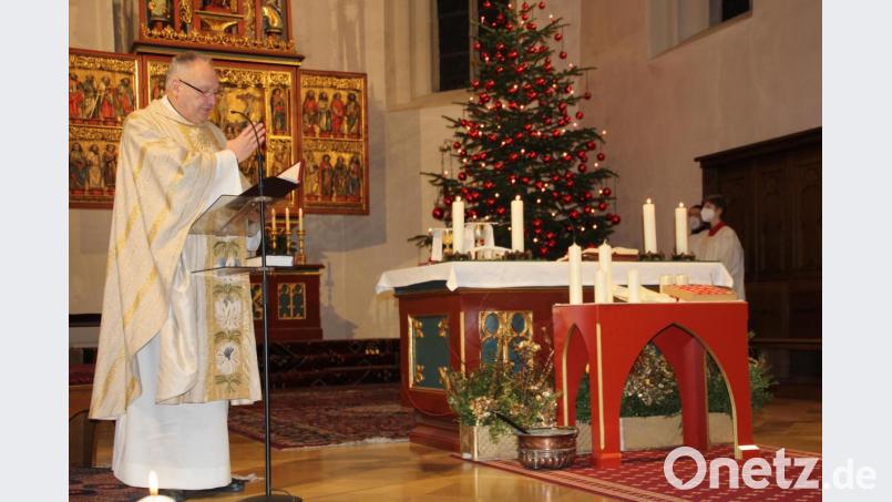 Stadtpfarrer Georg Flierl segnet zu Beginn des Gottesdienstes die vor dem Altar bereitgestellten Kerzen. Bild: kro