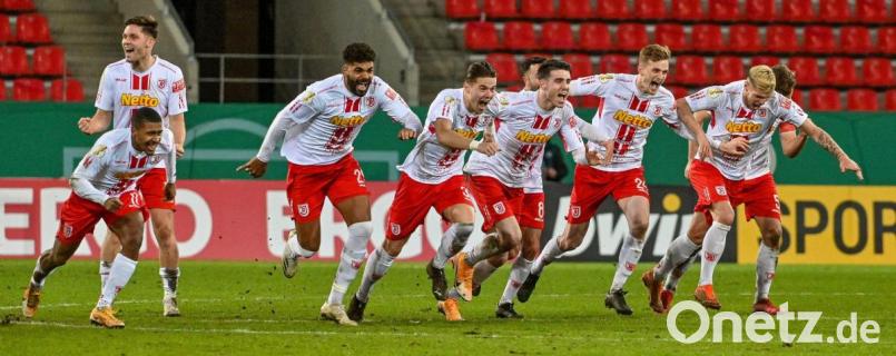 Der Moment des größten Pokalerfolgs in der Vereinsgeschichte des SSV Jahn Regensburg: Max Besuschkow hatte soeben den entscheidenden Elfmeter gegen den 1. FC Köln verwandelt, seine Mitspieler sprinteten ihm anschließend alle entgegen. Bild: Armin Weigel^/dpa