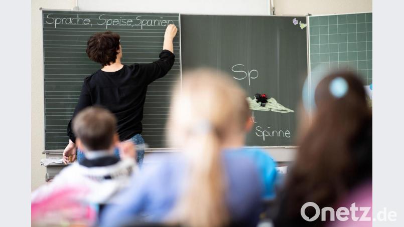 Eine Lehrerin schreibt in einer Schule an die Tafel. Symbolbild: Sebastian Gollnow/dpa