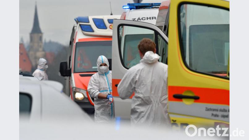 Tschechien, Cheb: Medizinische Mitarbeiter tragen Schutzkleidung und stehen vor Krankenwagen. Um Krankenhäuser zu entlasten, wurden Patienten mit mäßigem Krankheitsverlauf per Krankenwagen nach Prag, Pilsen und Mittelböhmen gebracht. Bild: Slavomír Kubeš/dpa